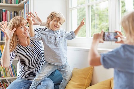 family looking at smart phone - Young boy taking photograph of mother and brother, using smartphone Stock Photo - Premium Royalty-Free, Code: 614-08877696