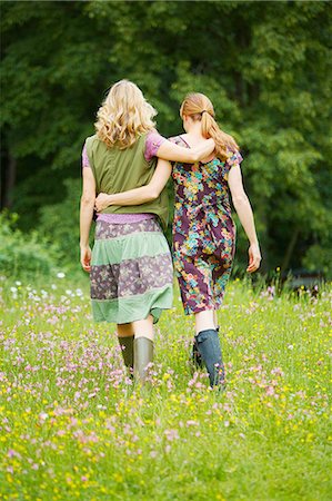 rubber boots - Rear view of two women walking in wildflower meadow Stock Photo - Premium Royalty-Free, Code: 614-08877753