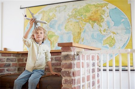 simsearch:614-08872573,k - Boy sitting in front of world map playing with toy aeroplane Stock Photo - Premium Royalty-Free, Code: 614-08877791