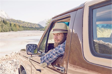 river and off road - Mid adult man sitting in truck, leaning out window, looking at camera Stock Photo - Premium Royalty-Free, Code: 614-08877817