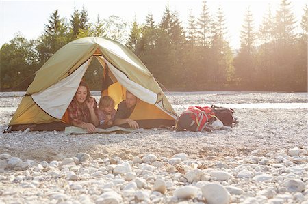 simsearch:614-08877825,k - Family lying on fronts side by side in unzipped tent, looking at map Stock Photo - Premium Royalty-Free, Code: 614-08877844