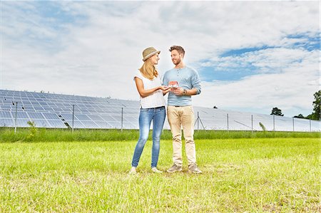 simsearch:614-06043348,k - Young couple standing in field, holding small model of house, next to solar farm Stock Photo - Premium Royalty-Free, Code: 614-08877852