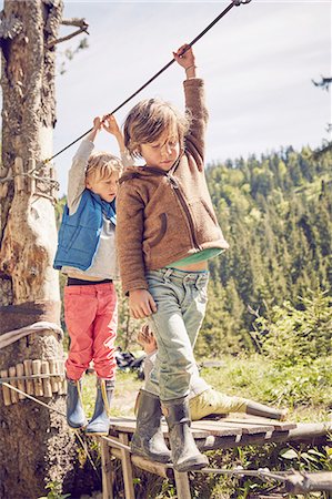 flexibility - Two children walking across single rope bridge Stock Photo - Premium Royalty-Free, Code: 614-08877987
