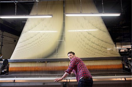 simsearch:614-08878042,k - Overhead portrait of young male weaver at old weaving machine in textile mill Stockbilder - Premium RF Lizenzfrei, Bildnummer: 614-08878037