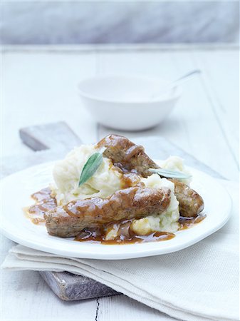 simsearch:649-06812340,k - Still life of sausages, mashed potatoes and gravy with sage garnish on white plate Photographie de stock - Premium Libres de Droits, Code: 614-08878142