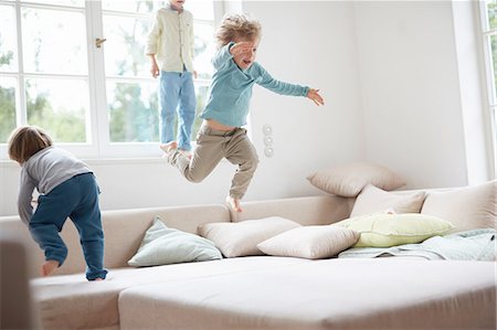 simsearch:614-07486968,k - Three young boys jumping on sofa Fotografie stock - Premium Royalty-Free, Codice: 614-08878199