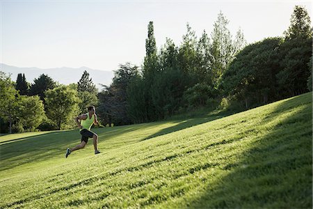 Young man doing training run on hill in park Stock Photo - Premium Royalty-Free, Code: 614-08878424