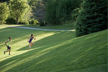 Young man and woman doing training runs on hill in park Stock Photo - Premium Royalty-Free, Code: 614-08878422