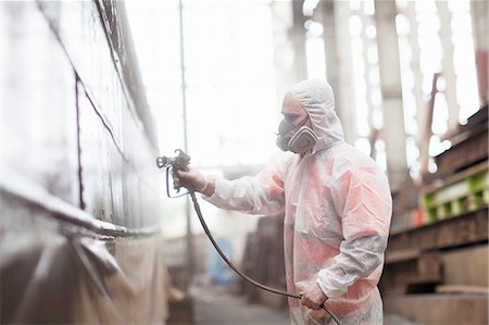 paint man - Worker spraypainting boat in shipyard Stock Photo - Premium Royalty-Free, Code: 614-08878517