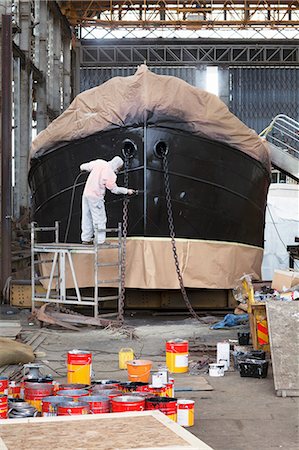 paint - Worker on top of scaffolding painting boat in shipyard Photographie de stock - Premium Libres de Droits, Code: 614-08878518