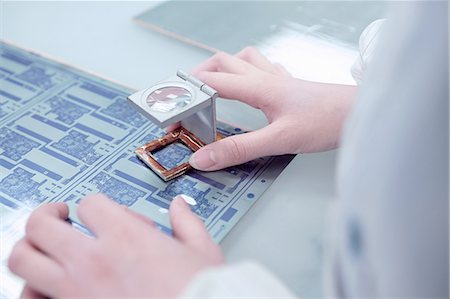 Hands of female worker inspecting flex circuit in flexible electronics factory Fotografie stock - Premium Royalty-Free, Codice: 614-08878567