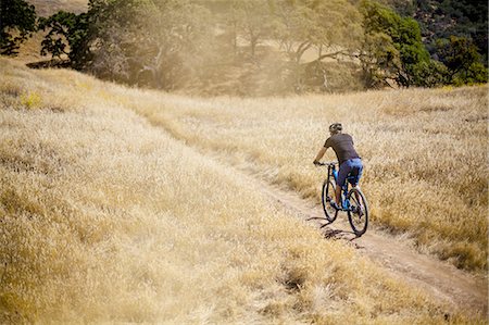 Elevated rear view of young man mountain biking on dirt track, Mount Diablo, Bay Area, California, USA Stock Photo - Premium Royalty-Free, Code: 614-08878600