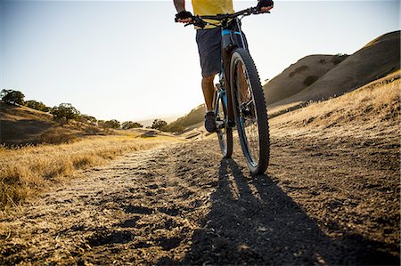 simsearch:614-08878600,k - Silhouetted cropped view of young man mountain biking down dirt track, Mount Diablo, Bay Area, California, USA Photographie de stock - Premium Libres de Droits, Code: 614-08878614