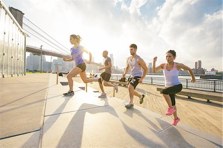 running side view - Four young adult running friends running up riverside stairs, New York, USA Stock Photo - Premium Royalty-Free, Code: 614-08878660