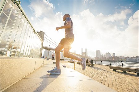 Young male runner running up stairs on riverside, New York, USA Stock Photo - Premium Royalty-Free, Code: 614-08878662