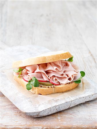 Wafer thin ham, wholegrain mustard, sliced gherkins and radish sandwich on sliced white bread Stock Photo - Premium Royalty-Free, Code: 614-08878714