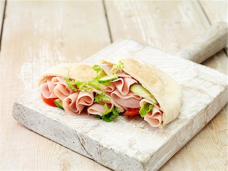 delicatessen food - Wafer thin ham, salad leaves, tomato and cucumber on whitewashed cutting board Foto de stock - Sin royalties Premium, Código: 614-08878737