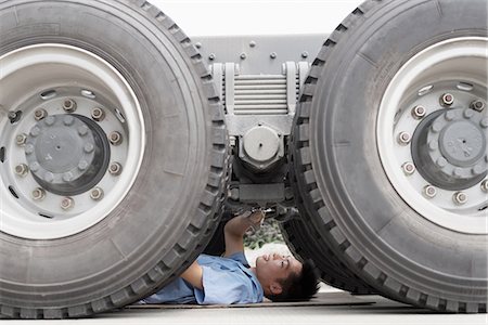 Male factory worker inspecting underneath truck in crane factory, China Stock Photo - Premium Royalty-Free, Code: 614-08878846