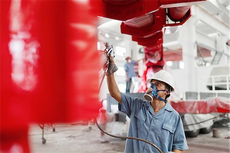 simsearch:614-08878042,k - Male factory worker spray painting a red crane in factory workshop, China Stockbilder - Premium RF Lizenzfrei, Bildnummer: 614-08878854