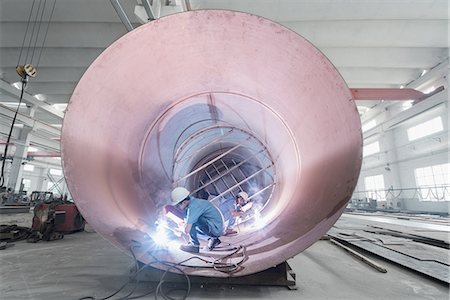 simsearch:632-03500560,k - Male welders working in industrial pipe at crane factory, China Photographie de stock - Premium Libres de Droits, Code: 614-08878860