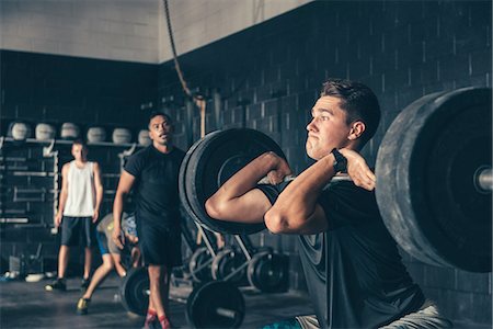 Male trainer and crossfitter training with barbell in gym Stock Photo - Premium Royalty-Free, Code: 614-08878905