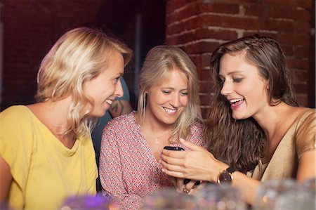 simsearch:649-09209314,k - Young women smiling at smartphone in club Stock Photo - Premium Royalty-Free, Code: 614-08878930