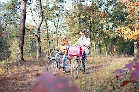 simsearch:614-08308003,k - Front view of teenage girls walking in forest pushing bicycles Fotografie stock - Premium Royalty-Free, Codice: 614-08879023