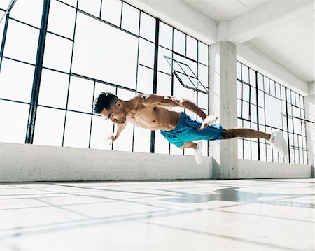 simsearch:614-08879113,k - Low angle view of young man in gym doing mid air push up Stockbilder - Premium RF Lizenzfrei, Bildnummer: 614-08879106