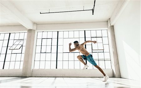 simsearch:614-08879114,k - Side view of young man in gym doing powerful running stance Stock Photo - Premium Royalty-Free, Code: 614-08879108