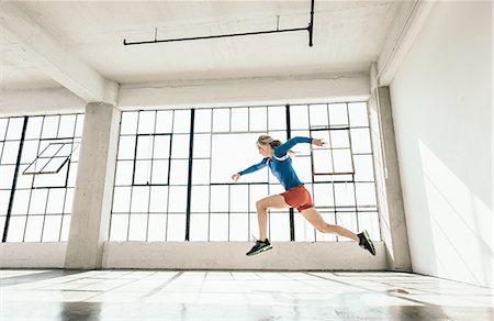 simsearch:614-08879114,k - Side view of young woman in gym doing powerful mid air running stance Stock Photo - Premium Royalty-Free, Code: 614-08879109