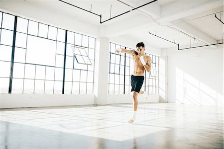 simsearch:614-08879114,k - Full length front view of young man in gym in boxing stance Stock Photo - Premium Royalty-Free, Code: 614-08879111