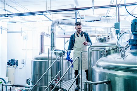 simsearch:614-08879201,k - Young man in brewery wearing apron and protective gloves looking at smartphone Stockbilder - Premium RF Lizenzfrei, Bildnummer: 614-08879207