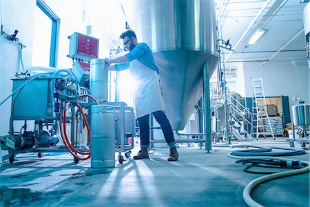 simsearch:614-08879227,k - Low angle side view of young man in brewery by conical fermentation tank attaching hose to canisters Stockbilder - Premium RF Lizenzfrei, Bildnummer: 614-08879224