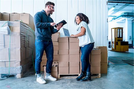 simsearch:614-08879232,k - Full length view of colleagues in warehouse looking at digital tablet and laptop Photographie de stock - Premium Libres de Droits, Code: 614-08879233