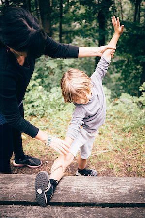 Boy with leg raised on picnic table stretching, mother helping, Bludenz, Vorarlberg, Austria Photographie de stock - Premium Libres de Droits, Code: 614-08879289