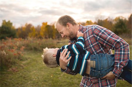 simsearch:614-06897021,k - Father carrying son in arms playfully, face to face smiling Stock Photo - Premium Royalty-Free, Code: 614-08879317