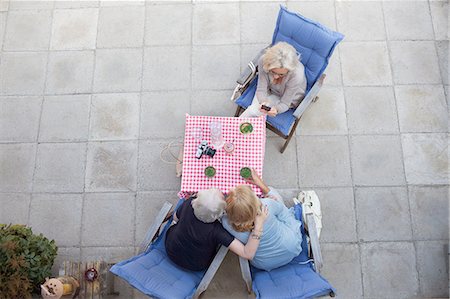 simsearch:614-09270617,k - Three women sitting in garden, enjoying drink, overhead view Photographie de stock - Premium Libres de Droits, Code: 614-08879357
