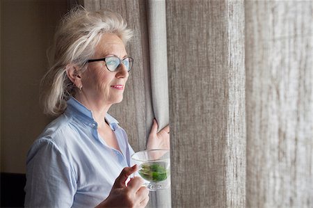 simsearch:614-08884947,k - Senior woman holding drink, looking out of window Foto de stock - Royalty Free Premium, Número: 614-08879368