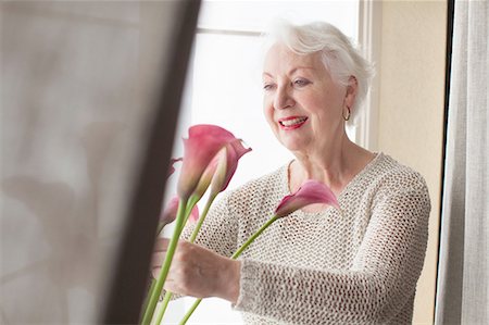 simsearch:614-08884947,k - Senior woman arranging flowers ion window sill Foto de stock - Royalty Free Premium, Número: 614-08879371