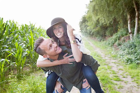 simsearch:614-08879491,k - Mid adult man giving girlfriend piggy back in field Stock Photo - Premium Royalty-Free, Code: 614-08879488