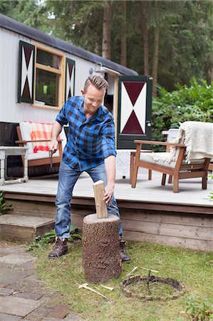 Mid adult man chopping logs at chalet Stock Photo - Premium Royalty-Free, Code: 614-08879497