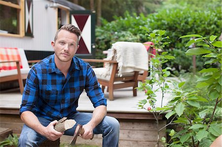 Portrait of mid adult man chopping logs at chalet Stock Photo - Premium Royalty-Free, Code: 614-08879498