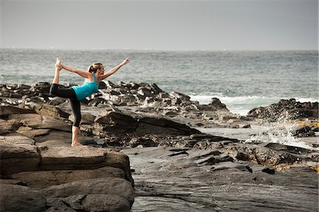 Woman practicing yoga on rock formation Stock Photo - Premium Royalty-Free, Code: 614-08870189