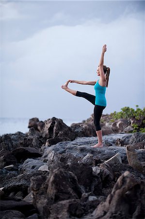 Woman practicing yoga on rock formation Stock Photo - Premium Royalty-Free, Code: 614-08870194
