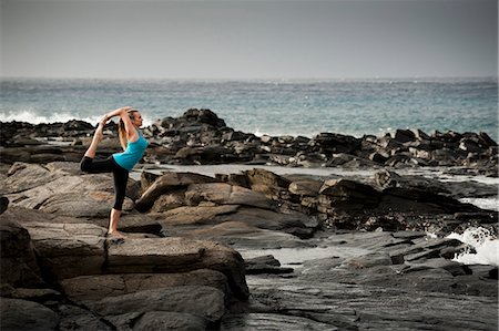 Woman practicing yoga on rock formation Stock Photo - Premium Royalty-Free, Code: 614-08870190