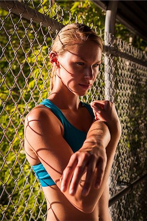 simsearch:632-09192292,k - Woman stretching by fence Fotografie stock - Premium Royalty-Free, Codice: 614-08870203