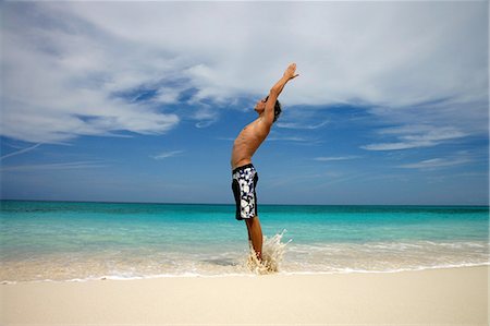 paradise island bahamas beach - Man practicing yoga on tropical beach Stock Photo - Premium Royalty-Free, Code: 614-08870314