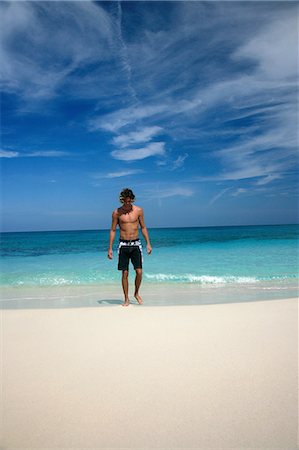 paradise island bahamas beach - Man walking on tropical beach Stock Photo - Premium Royalty-Free, Code: 614-08870316