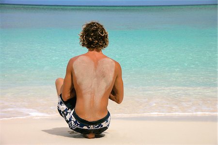 paradise island bahamas beach - Man sitting on tropical beach Stock Photo - Premium Royalty-Free, Code: 614-08870317