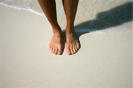 paradise island bahamas beach - Close up of mans feet on beach Stock Photo - Premium Royalty-Free, Code: 614-08870318